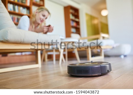 Vacuum robot vacuuming parquet floor in the living room Stock photo © 