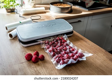 Vacuum strawberries packaging for long-term storage. They use of a vacuum sealer for long-term storage of products. Vacuum packing machine - Shutterstock ID 2180024207