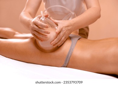 Vacuum Therapy for Buttocks. Woman using suction cup pump up on butt to lift it up