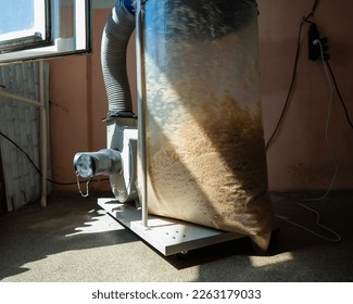 Vacuuming sawdust while sawing wood. Chip blower in furniture production.  - Powered by Shutterstock