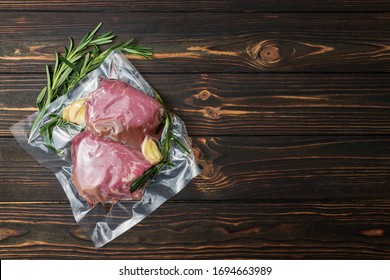 Vacuum-packed meat, on a wooden board, steak. Top view.