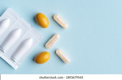 Vaginal Suppositories On Blue Background. Top View. Copy Space. Vulvovaginal Infections Treatment. Gynecological Medicines For Womens Health In Form Of Suppository, Capsules And Oval Shaped Pill. 