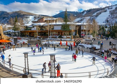 Vail, Colorado/USA-December, 30,2018. Small Town At The Base Of Vail Mountain, Gateway For Winter Sports. People Walking On Busy Streets Next To Skating Rink . Stores, Mountains In The Background.