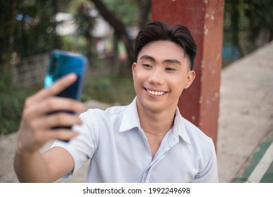 A Vain Handsome Young Man Takes A Selfie Of Himself While At A Basketball Court. A Narcissistic Asian Guy.