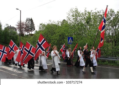 VAKSDAL, NORWAY - MAY 17: Flag bearers dressed in traditional costumes carry flags as they lead a Norwegian National Day parade through the village of Vaksdal on 17 May 2011.