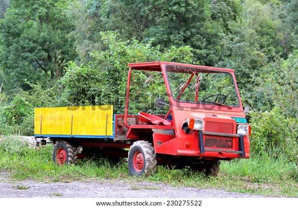 VALAIS, SWITZERLAND - AUGUST\
5, 2014: Old red agricultural flat-bed truck in a small Alpine\
village.
