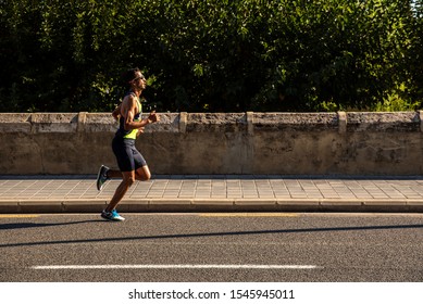 Valencia, Spain - October 27, 2019: Participant In A Half Marathon Race Running On The Asphalt Of The City Of Valencia.