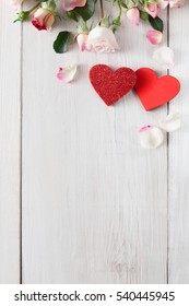 Valentine Background With Pink Rose Flowers And Handmade Wooden Hearts, Top View On White Rustic Wood, Vertical Orientation. Happy Lovers Day Mockup, Copy Space