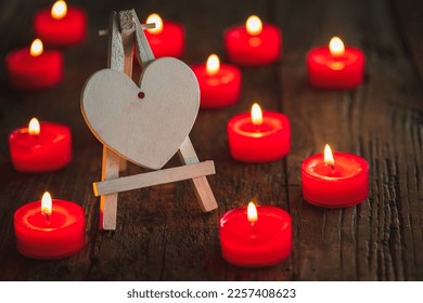 Valentine card motive, valentines greetings, wedding concept _ red candlellights with white heart on wooden dark underground - Shutterstock ID 2257408623