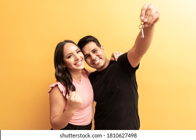 Valentine Couple On Yellow Background Holding House Key. New Home Concept