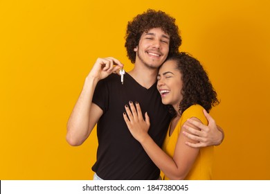 valentine couple on yellow background holding house key. New home concept