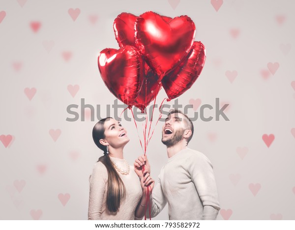 バレンタインカップル ハート型の風船を持ち 笑う 微笑む美人少女とハンサムな彼氏のポートレート 幸せな家族 愛 ハッピーバレンタインデー の写真素材 今すぐ編集