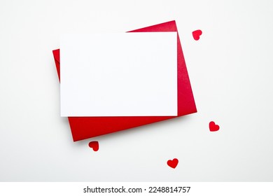 Valentine Day card mockup with hearts and red envelope on white background, top view, flat lay. Blank wedding invitation, flyer, greeting card with holiday decor. Empty love letter with copy space - Shutterstock ID 2248814757