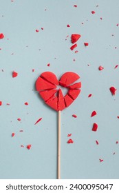 Concepto del día de San Valentín con corazón rojizo de lollipop en la parte superior del fondo azul pastel. Tarjeta de saludo plana y laica.
