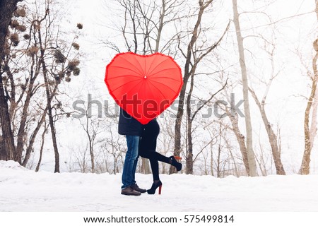 Valentine Day concept. Love in air.Couple in park with heart umbrella