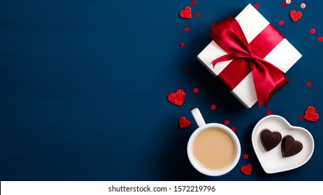 Valentine Day Concept. Top View Gift Box, Coffee Cup, Heart Shaped Candy On Blue Table. Flat Lay Style Composition. Love, Romantic Morning Breakfast Concept.