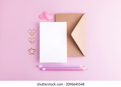 Valentine day greeting mock up with blank card, envelope, hearts and colorful pencils. Creative knolling flat lay with empty space.