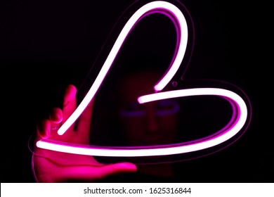 Valentine day. Hipster handsome man with neon signs. Neon sign pink heart. Party concept. Modern style. Neon sign.  - Powered by Shutterstock