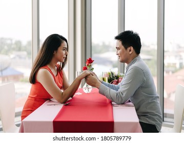 Valentine Festive Date At Restaurant Concept. Smile Asian Lover Couple Man And Woman Hold Your Hands Together And Eye To Eye. Romantic Dinner At Restaurant