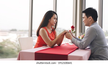 Valentine Festive Date At Restaurant Concept. Smile Adult Asian Lover Couple Man And Woman Hand Hold Together. Romantic Dinner At Restaurant