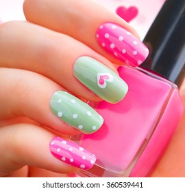 Valentine Nail Art Manicure. Valentine's Day Holiday Style Bright Manicure With Painted Hearts And Polka Dots. Bottle Of Nail Polish. Beauty Salon. Hand. Trendy Stylish Colorful Nails, Nailpolish