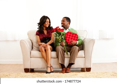 Valentine: Romantic Couple On Couch With Candy And Flowers