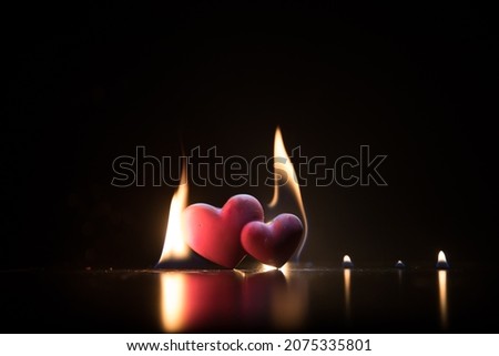Valentines background. Valentine's Day heart on a dark wooden table. Burning hearts. Heart in fire. Dark toned foggy background. Selective focus
