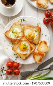 Valentine's breakfast, toast with fried egg in the shape of a heart served on a ceramic plate on a white table top view.