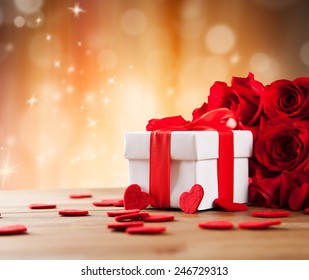 Valentines Concept With Bouquet Of Roses And Wrapped Gift On Wooden Table
