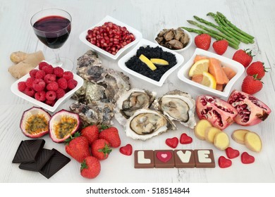 Valentines day aphrodisiac food and drink selection for good  sexual health forming a background over distressed white wood.