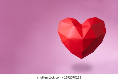 Valentines day background concept. Paper geometric volume heart on pink background with blank space for text.