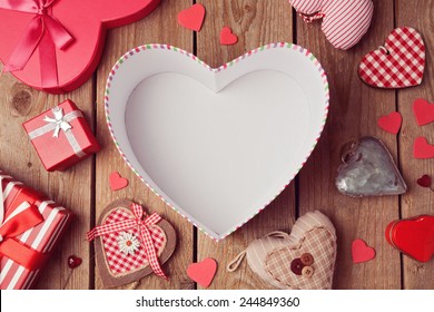 Valentine's day background with empty heart shape box on wooden table. View from above