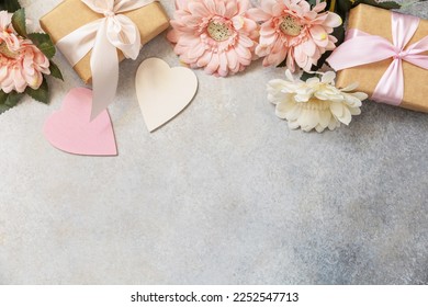 Valentine's Day background with gifts, beautiful flowers and hearts. Valentine's day, Womans day, wedding, birthday or mothers day greeting card. View from above. Copy space.