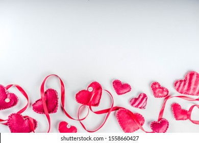 Valentines Day background with handmade red textile hearts,red ribbon and roses. White background  flaylay pattern top view copy space