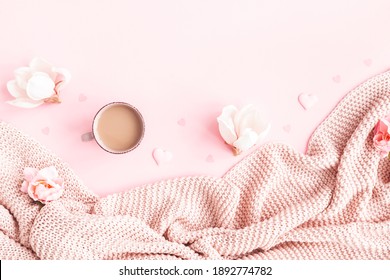 Valentine's Day background. Pink flowers, plaid, cup of coffee on pink background. Valentines day concept. Flat lay, top view, copy space