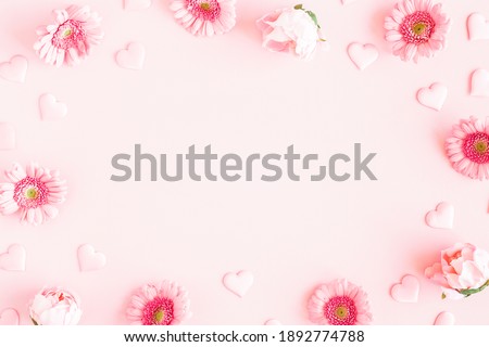 Valentine's Day background. Pink flowers, hearts on pastel pink background. Valentines day concept. Flat lay, top view, copy space