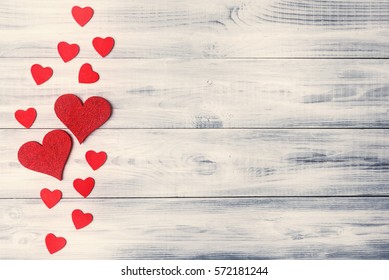 Valentine's day background with red hearts on wooden planks