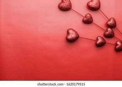 Valentines day background. Red tiny hearts on sticks on red background. Symbol of love.