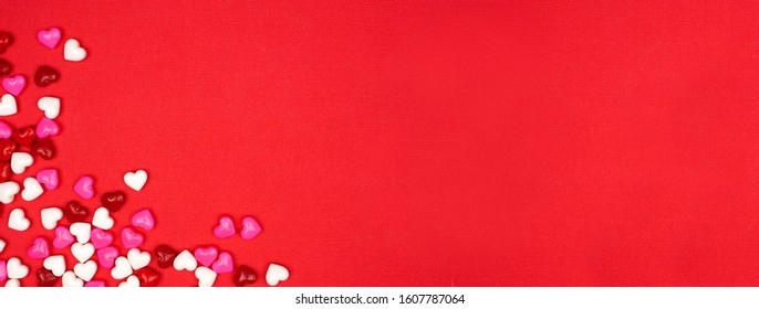 Valentines Day Banner With Candy Hearts Corner Border Over A Red Textured Background. Top View With Copy Space.