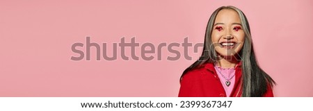 Valentines day banner, happy asian woman with heart shaped eye makeup posing on pink backdrop
