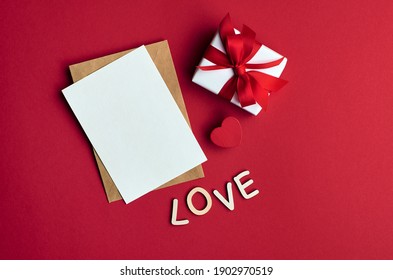 Valentines Day Card Mockup With Envelope And Gift Box With Heart On Red Paper Background, Top View, Copy Space