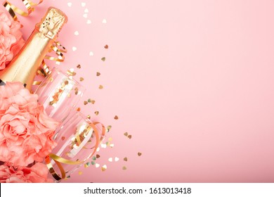 Valentinstag Champagner Flasche Flöte Gläser goldene Konfetti Herzen Rosen Blumen und Serpentine auf rosafarbenem Hintergrund mit Kopienraum für Text