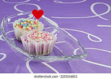 Valentine's Day cheesecake template with a heart, space for text. Two cheesecakes with a red heart as a flag in a glass vase like on the boat, on lilac material.  - Shutterstock ID 2253156811