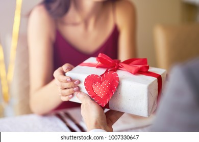 Valentine's Day concept. Happy couple in love with. A young loving couple celebrating Valentine's Day in the restaurant. Lovers give each other gifts. Romance restaurant for Valentine's Day- concept