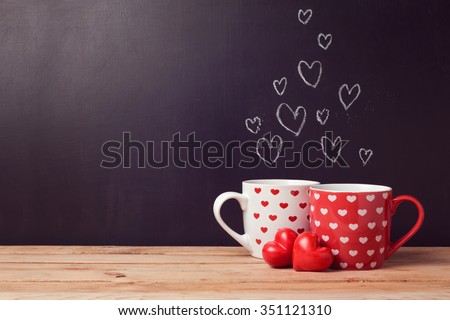 Valentine's day concept with hearts and cups over chalkboard background