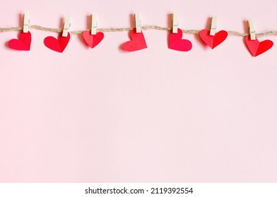 Valentine's Day concept, paper hearts hanging on clothespins. High quality photo