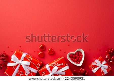 Valentine's Day concept. Top view photo of gift boxes with white ribbon bows heart shaped dish with sprinkles and chocolate candies on isolated red background with empty space