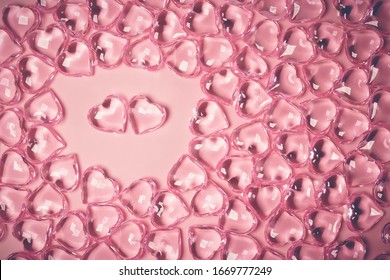 Valentines Day Concept. Two red hearts in an environment glass transparent hearts on pink background, glass heart glows, glass painting. Many red glass hearts. Love for Valentine's day. Copy space.