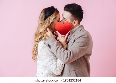 Valentine's Day. Couple kiss hidden by red heart. High quality photo