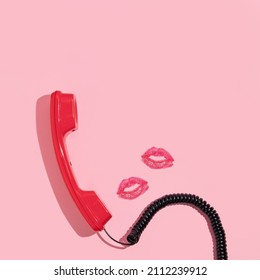 Valentines Day Creative Layout With Bright Red Retro Phone Handset And Kiss Prints On Pastel Pink Background. 80s Or 90s Retro Fashion Aesthetic Telephone And Kiss Concept. Minimal Romantic  Idea.